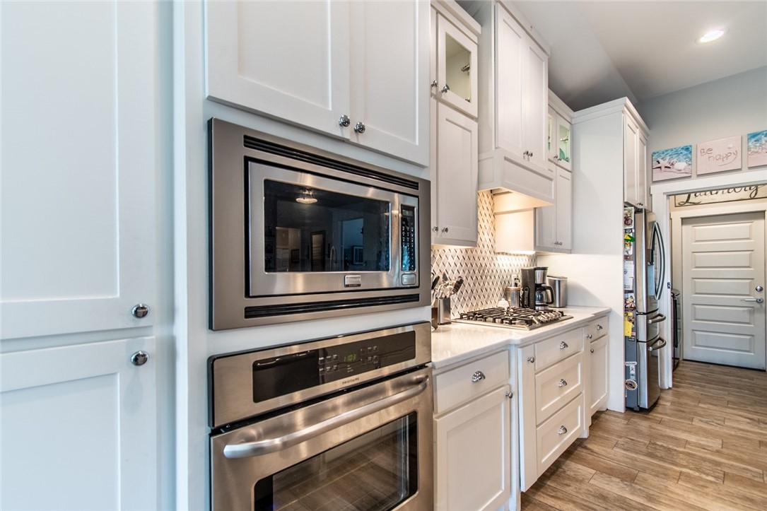 15422 Dyna Street Corpus Christi, TX 78418 - Photo 28 of 40 a kitchen with stainless steel appliances white cabinets and a stove top oven