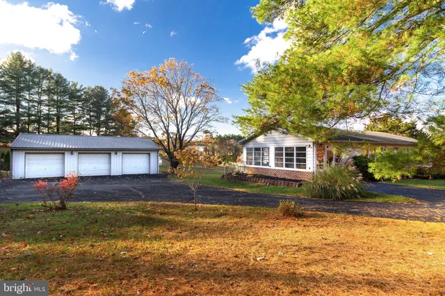 a front view of house with yard and trees in the background