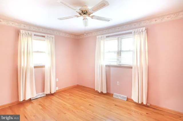 a view of a room with a ceiling fan and wooden floor