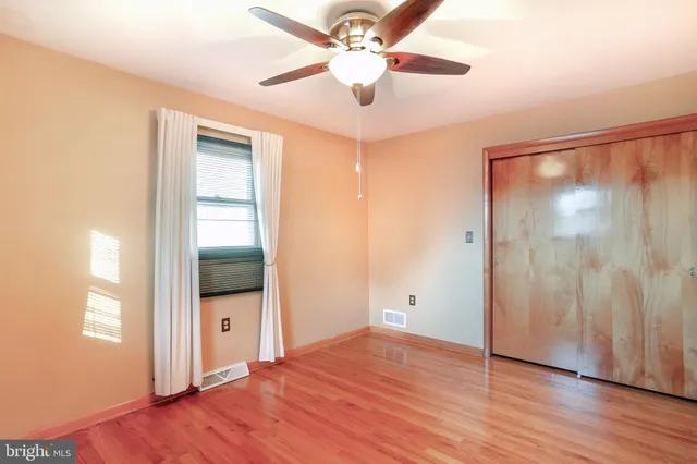 a view of a room with wooden floor and a ceiling fan