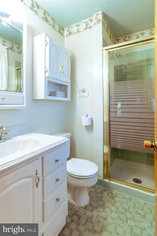 a bathroom with a granite countertop sink toilet a mirror a vanity and shower