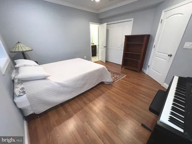 a bedroom with a bed and wooden floor