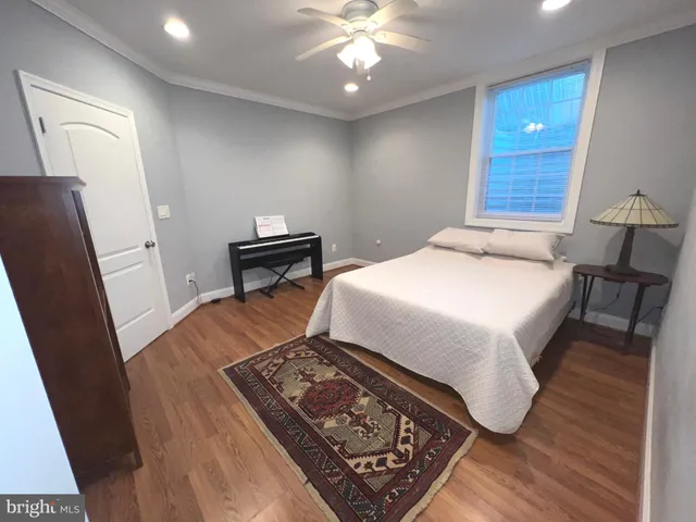 a bedroom with a bed and wooden floor