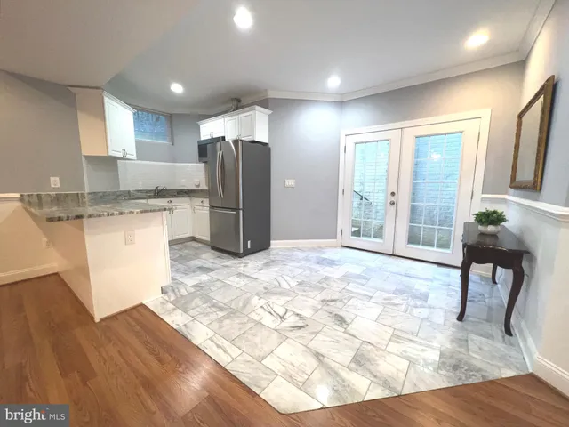 a kitchen with stainless steel appliances kitchen island granite countertop a refrigerator and a stove top oven