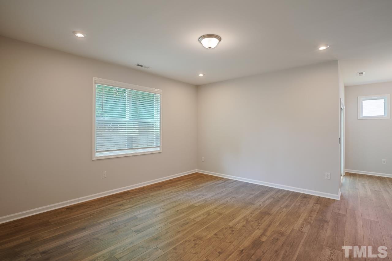 393 Madden Rose Loop Garner, NC 27529 - Photo 11 of 31 an empty room with wooden floor and windows