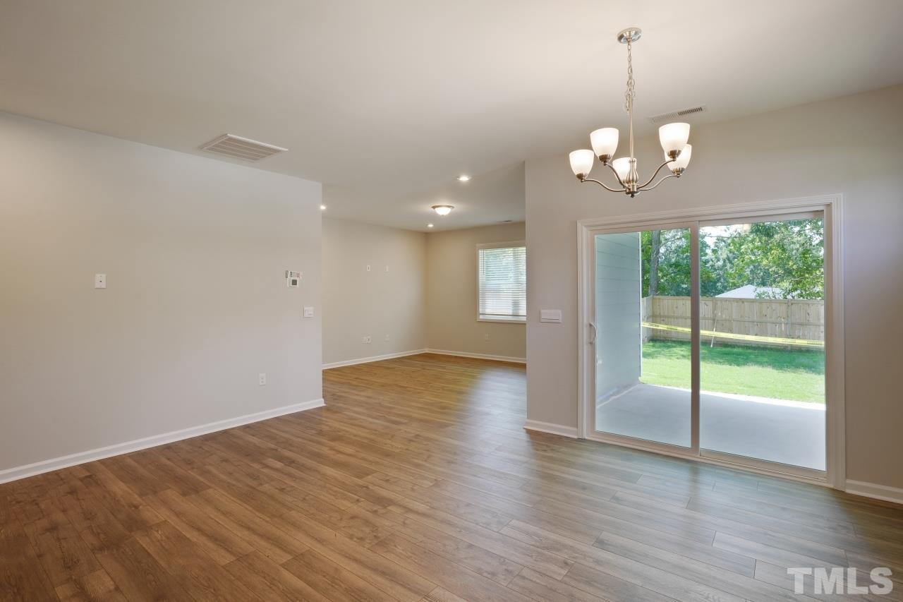 393 Madden Rose Loop Garner, NC 27529 - Photo 13 of 31 a view of a livingroom with a chandelier wooden floor and a ceiling fan