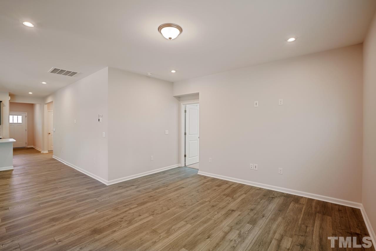 393 Madden Rose Loop Garner, NC 27529 - Photo 14 of 31 an empty room with wooden floor and windows