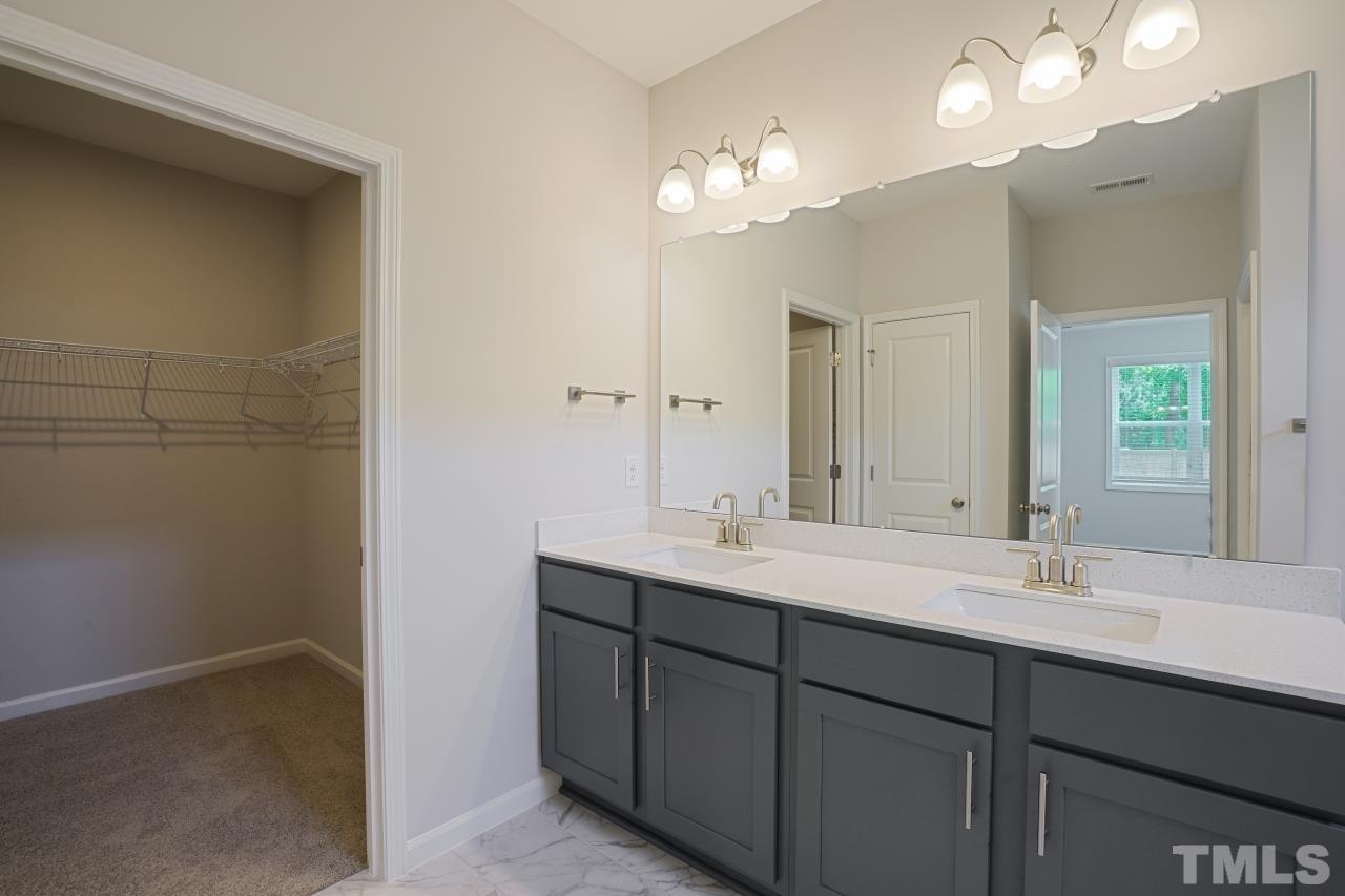 393 Madden Rose Loop Garner, NC 27529 - Photo 17 of 31 a bathroom with a double vanity sink and a mirror