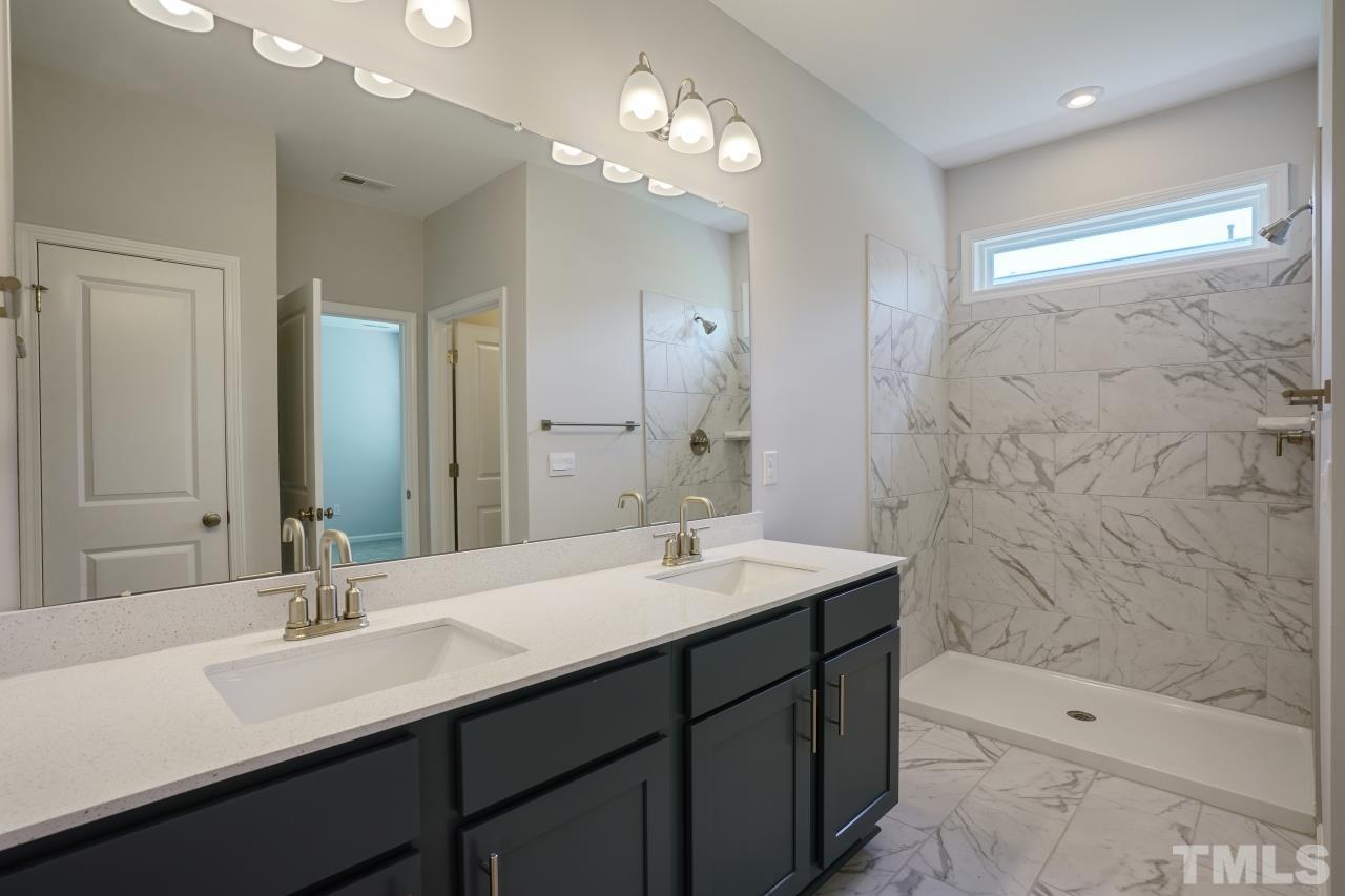 393 Madden Rose Loop Garner, NC 27529 - Photo 18 of 31 a bathroom with a sink double vanity granite tub shower and a mirror