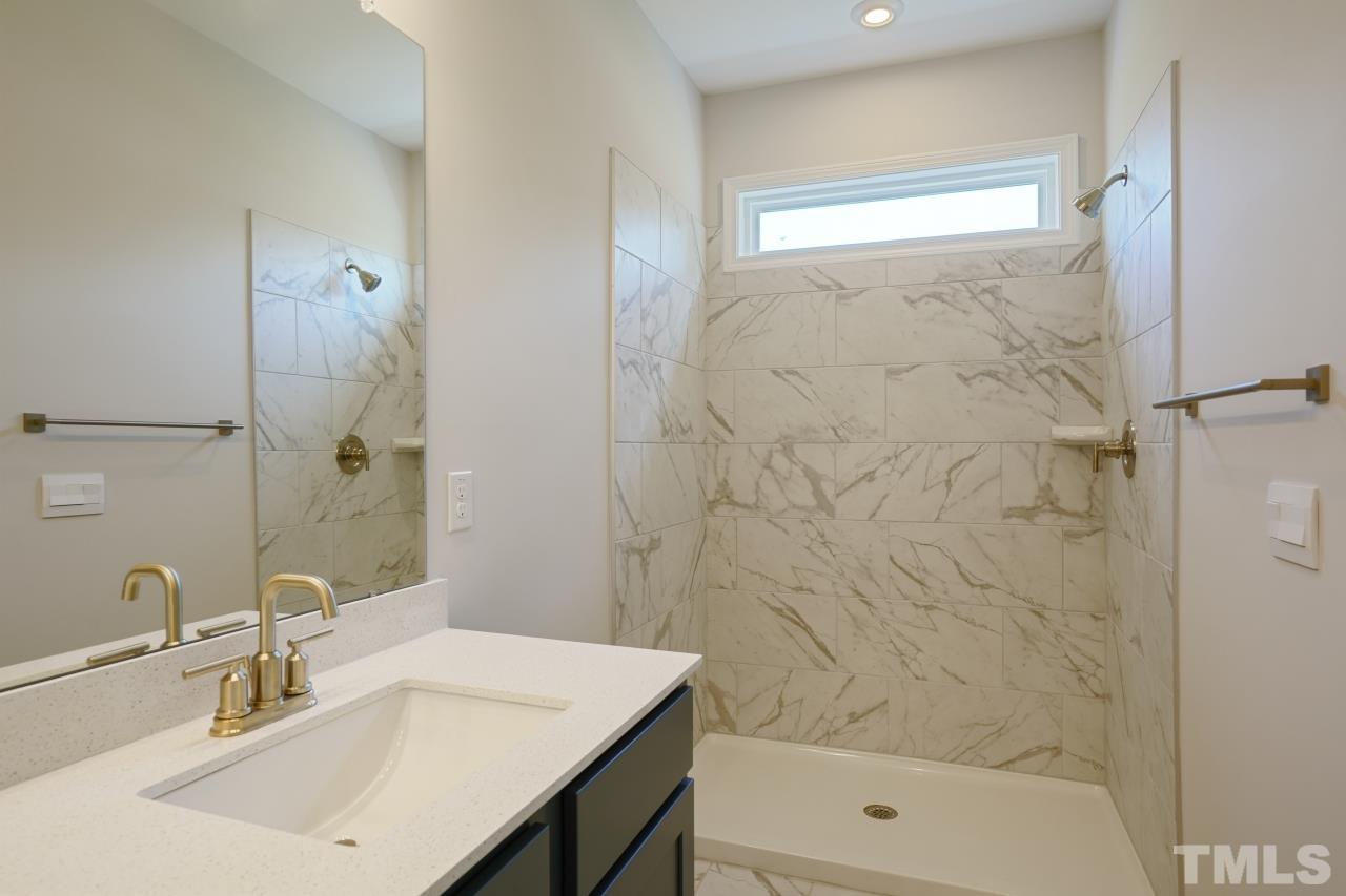 393 Madden Rose Loop Garner, NC 27529 - Photo 20 of 31 a bathroom with a sink a shower and a mirror