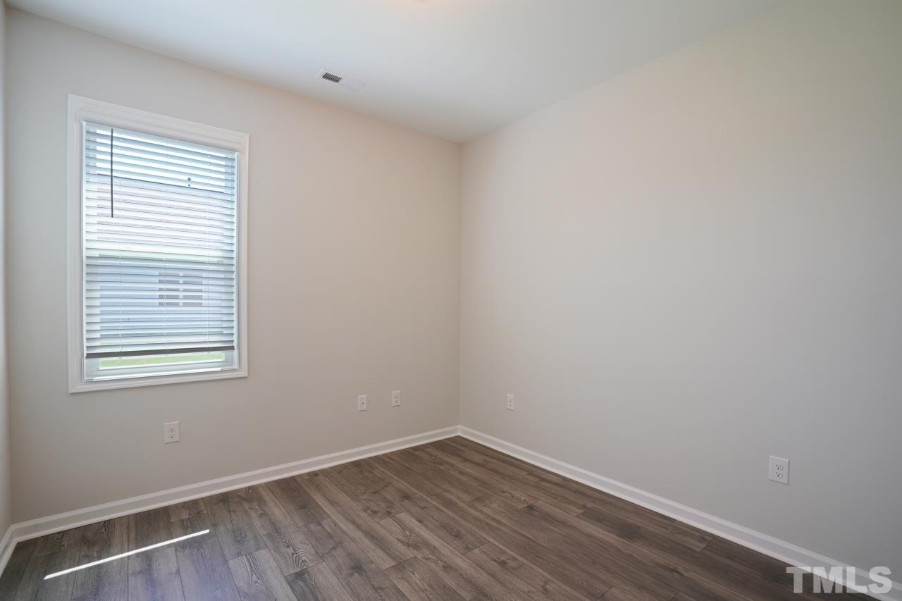 393 Madden Rose Loop Garner, NC 27529 - Photo 24 of 31 wooden floor in an empty room with a window