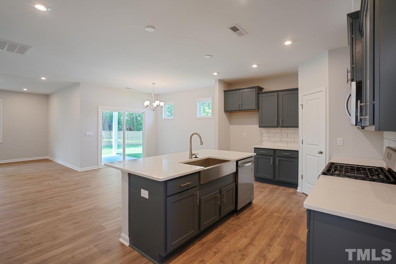 393 Madden Rose Loop Garner, NC 27529 - Photo 4 of 31 a kitchen with a sink appliances and cabinets