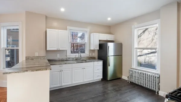 a kitchen with stainless steel appliances granite countertop a refrigerator and a sink