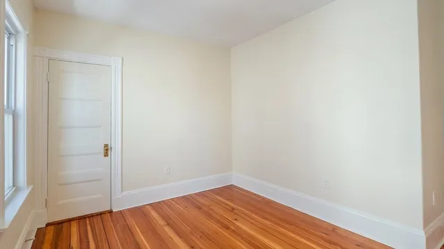 a view of a small space with wooden floor and a window