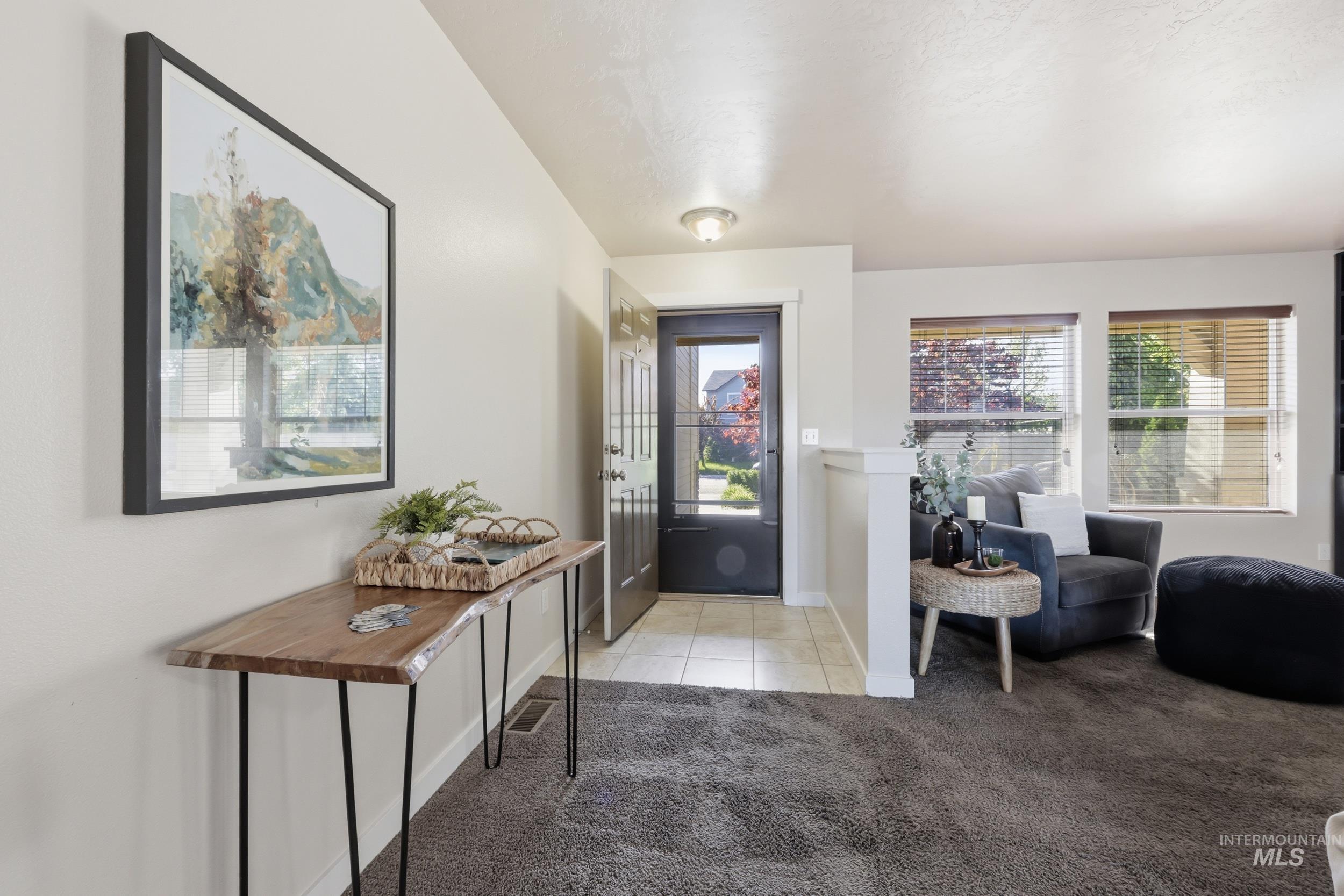 4855 South Chex Way Boise, ID 83709 - Photo 3 of 47 Entryway featuring a dark paneled door with glass inserts, neutral wall color, and a wood-finish console table