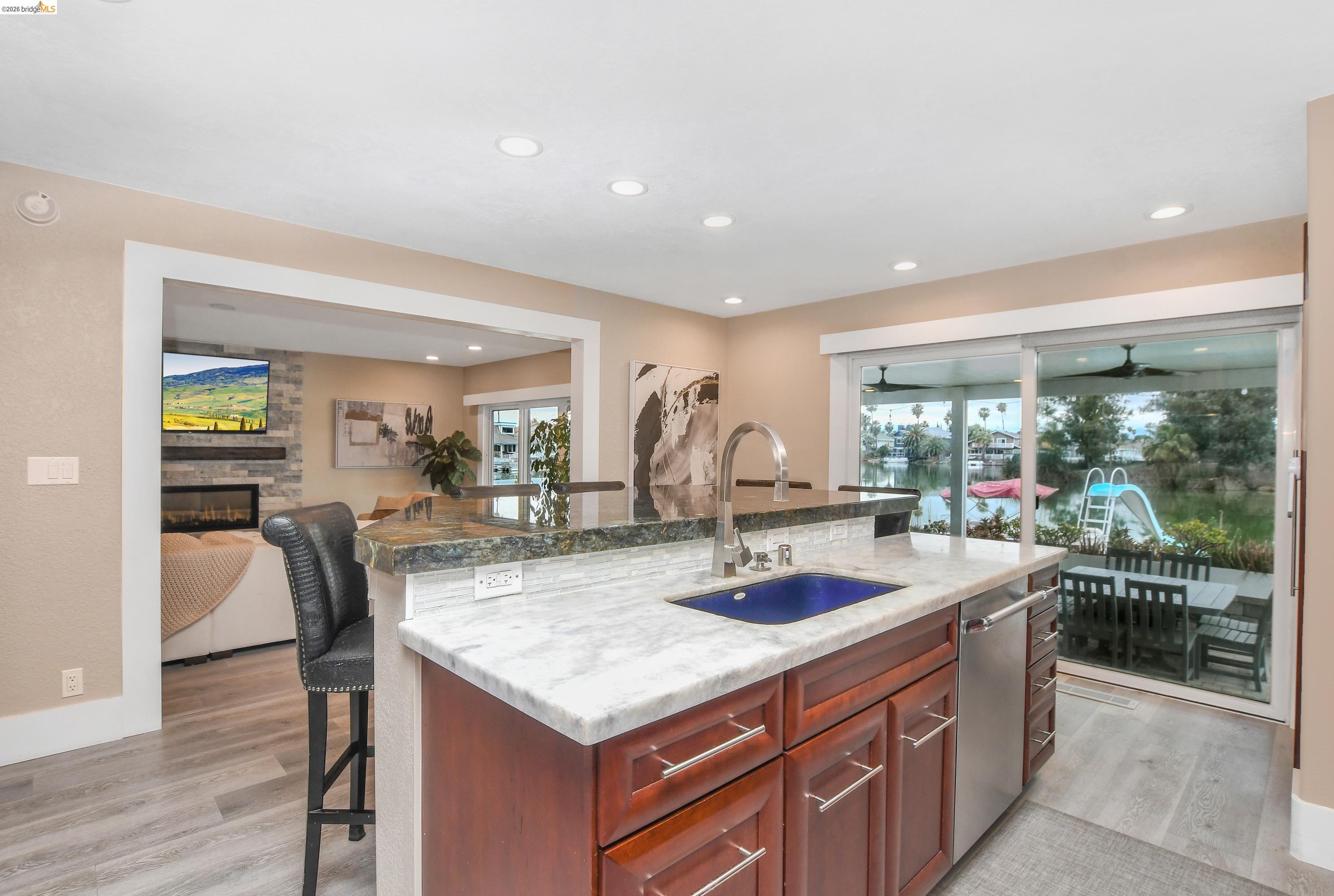 1432 Willow Lake Road Discovery Bay, CA 94505 - Photo 13 of 40 Kitchen island featuring a blue vessel sink, stainless steel faucet, and marble-finish countertop