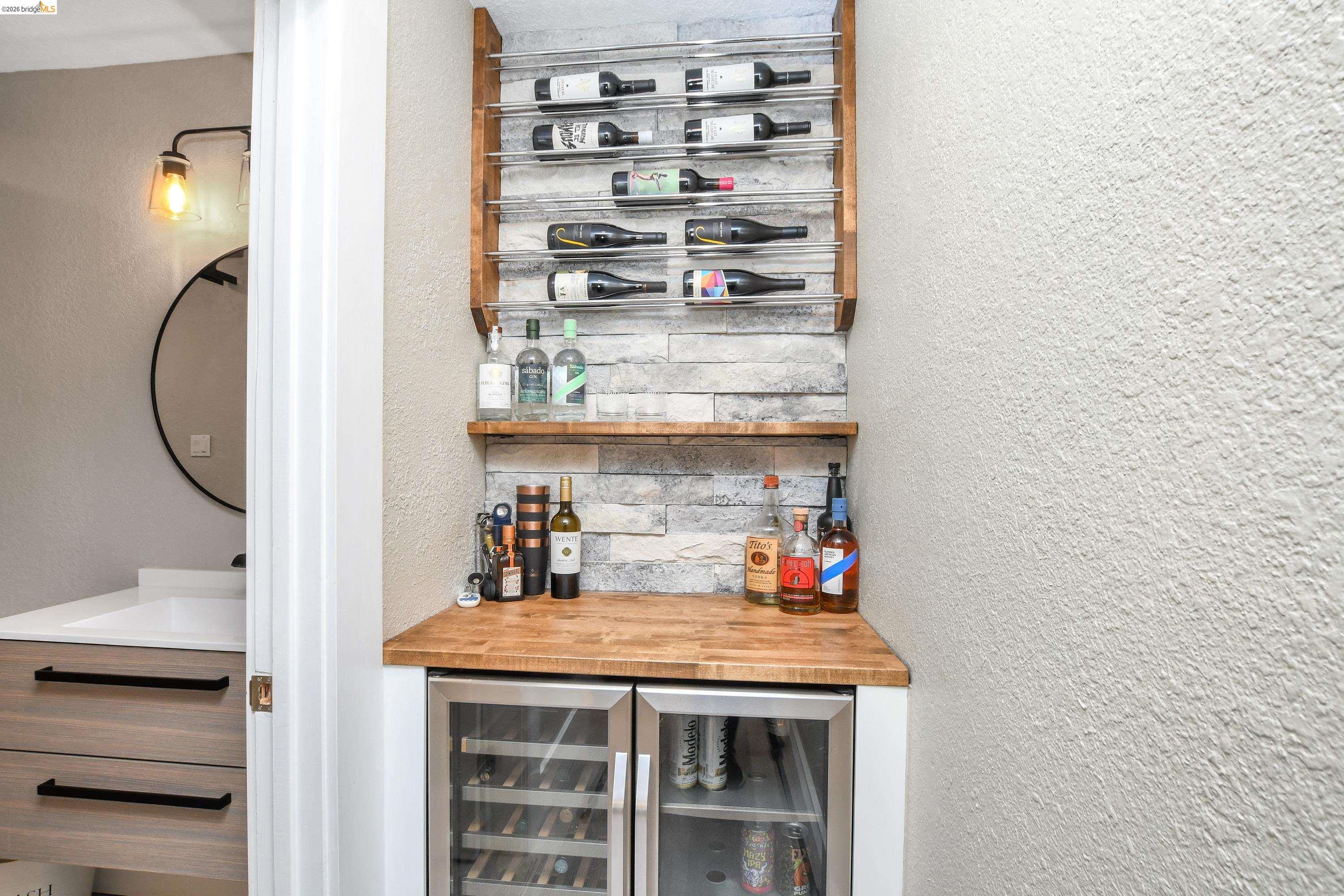 1432 Willow Lake Road Discovery Bay, CA 94505 - Photo 15 of 40 Built-in beverage station featuring stacked stone-look wall accents, wood-finish shelving, and a wood-finish countertop