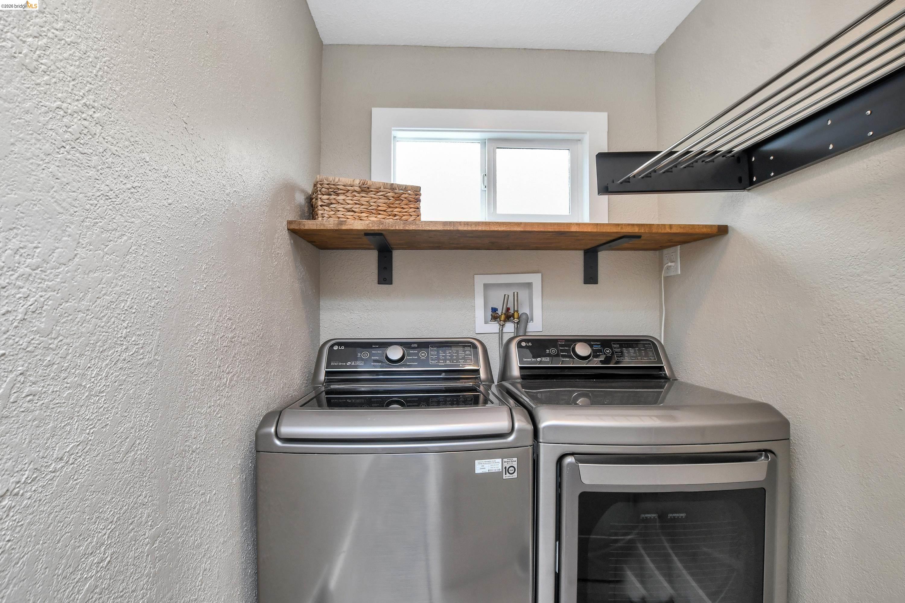 1432 Willow Lake Road Discovery Bay, CA 94505 - Photo 17 of 40 Dedicated laundry area featuring a window, wood-finish shelving with black metal supports, and a wall-mounted drying rack