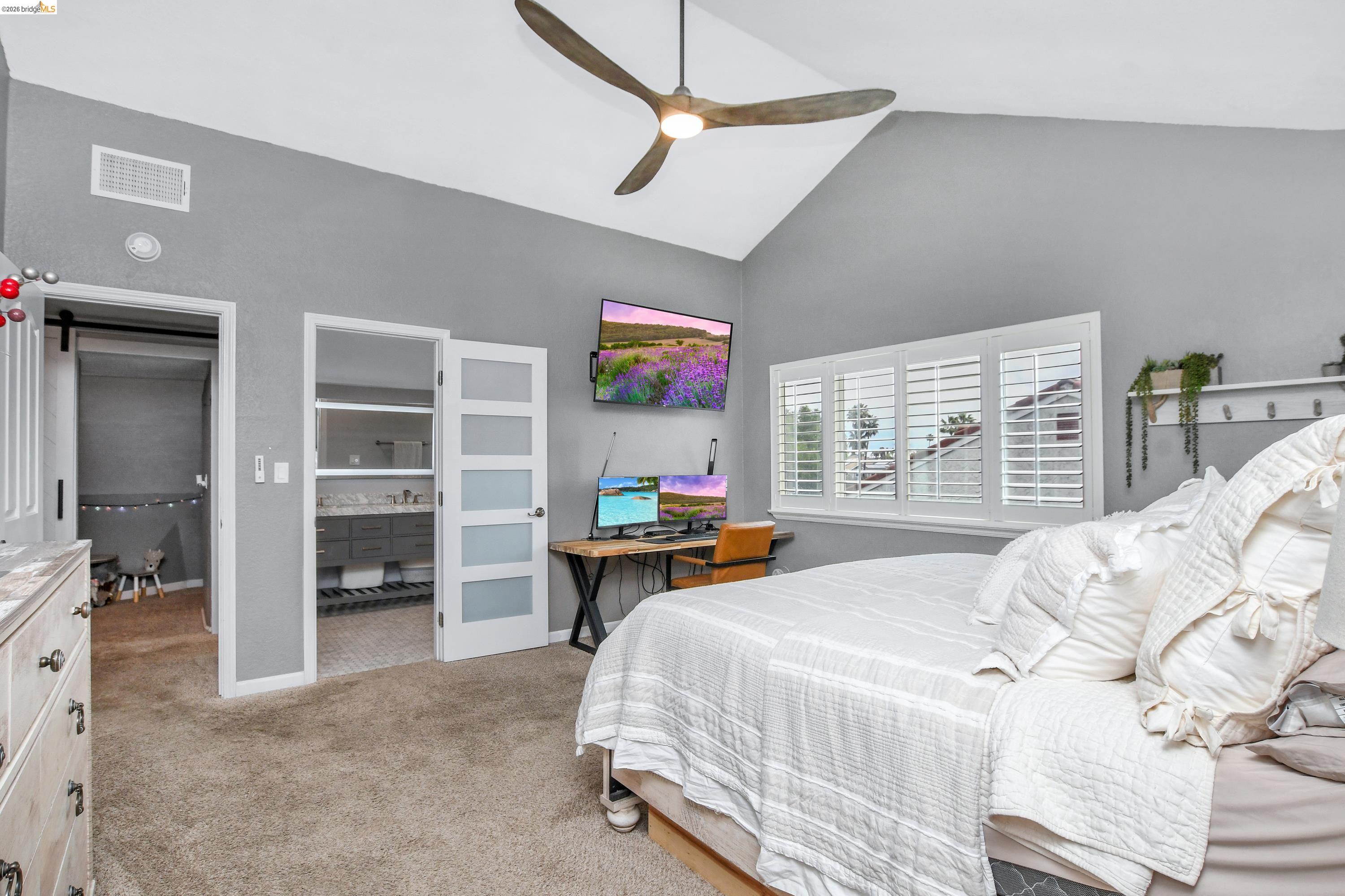 1432 Willow Lake Road Discovery Bay, CA 94505 - Photo 28 of 40 Vaulted ceiling with a wood-finish ceiling fan, window with white louvered shutters, and grey wall color
