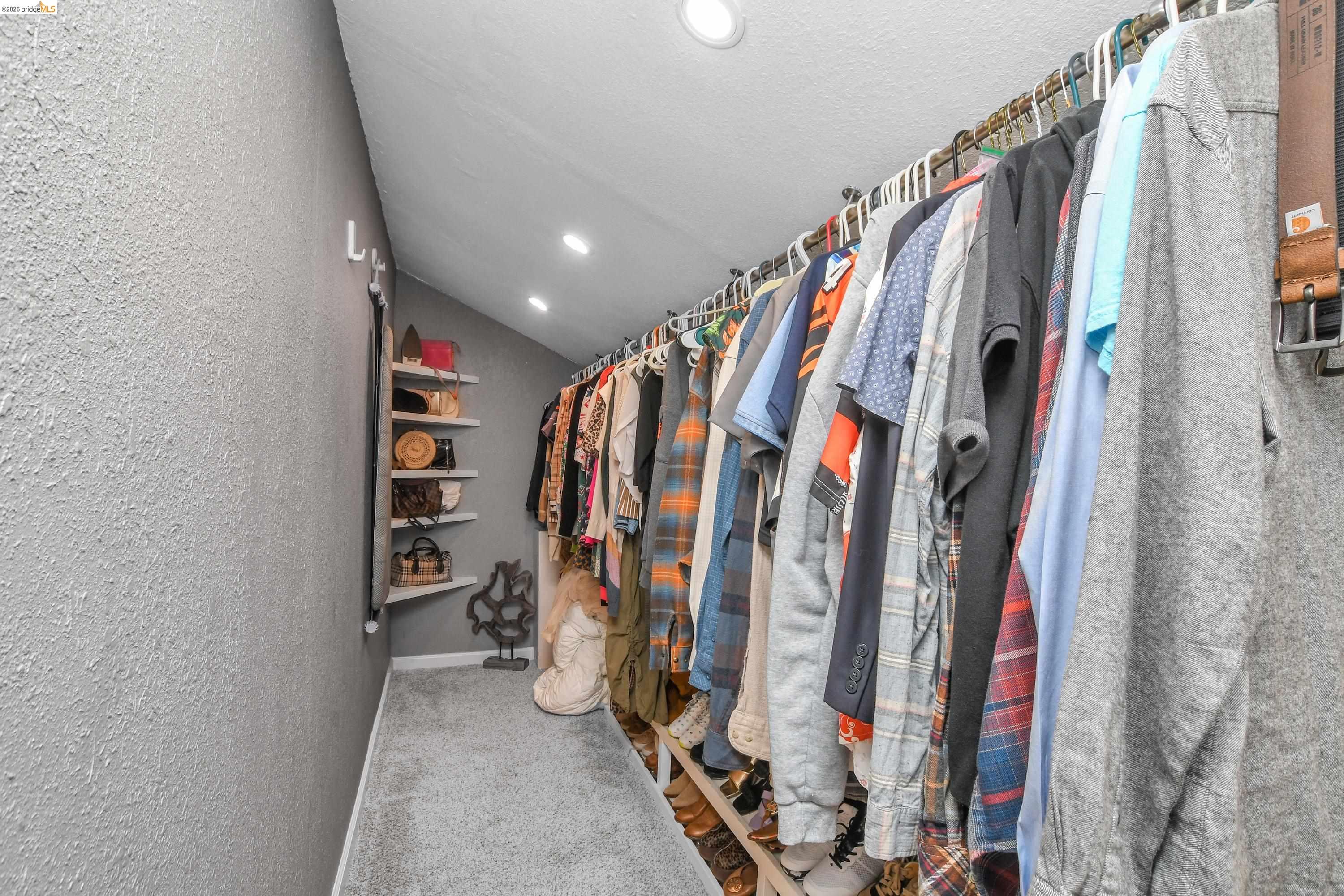 1432 Willow Lake Road Discovery Bay, CA 94505 - Photo 29 of 40 Angled ceiling closet featuring recessed lighting, a carpeted floor, built-in shelving, and ample hanging rod space