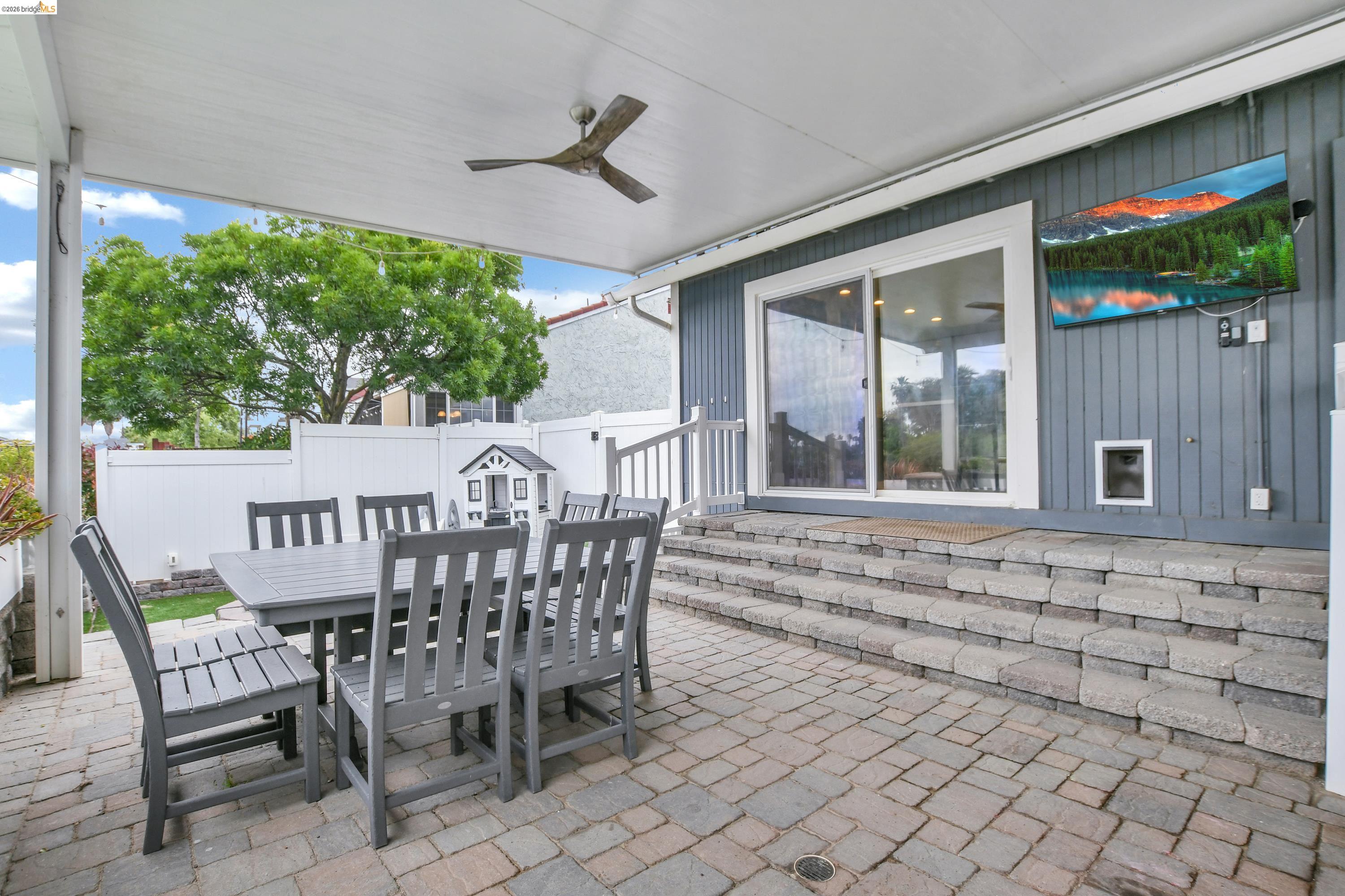 1432 Willow Lake Road Discovery Bay, CA 94505 - Photo 34 of 40 Covered patio featuring an outdoor ceiling fan, paver flooring, a sliding glass door, tiered stone steps, and siding exterior