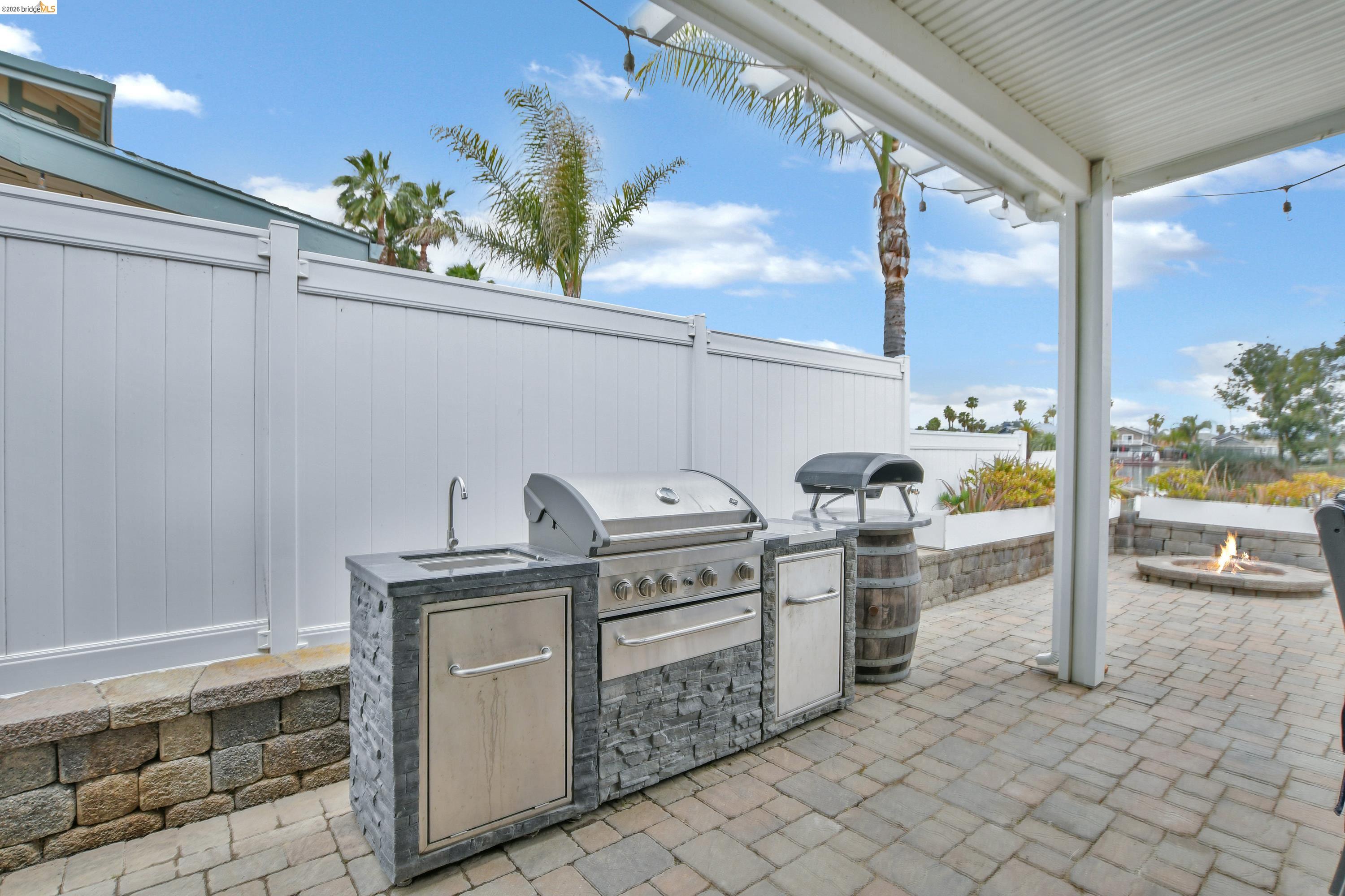 1432 Willow Lake Road Discovery Bay, CA 94505 - Photo 35 of 40 Outdoor kitchen featuring a built-in stainless steel grill, integrated sink, and stacked stone facade