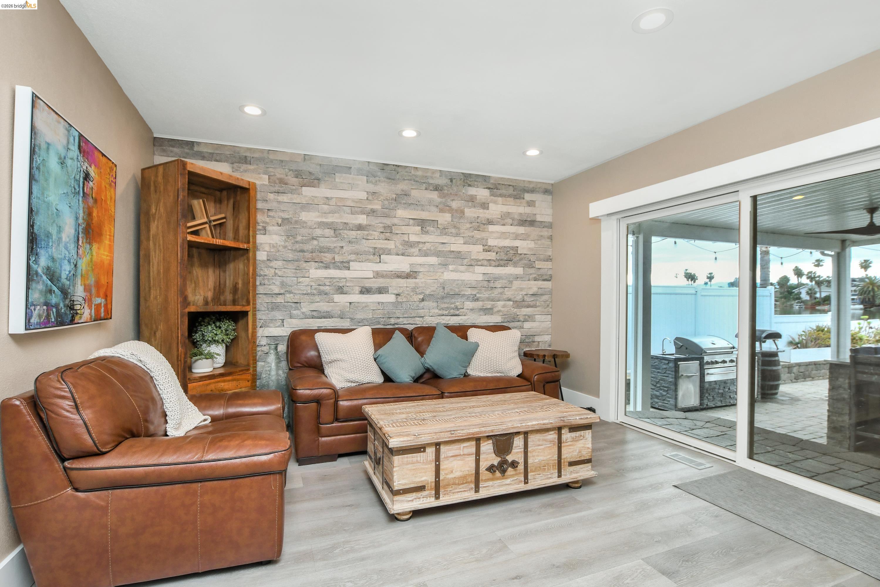 1432 Willow Lake Road Discovery Bay, CA 94505 - Photo 7 of 40 Living area featuring a stone accent wall, recessed lighting, and wood-finish flooring