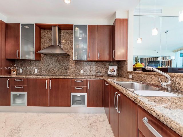 a kitchen with stainless steel appliances granite countertop a sink stove and cabinets
