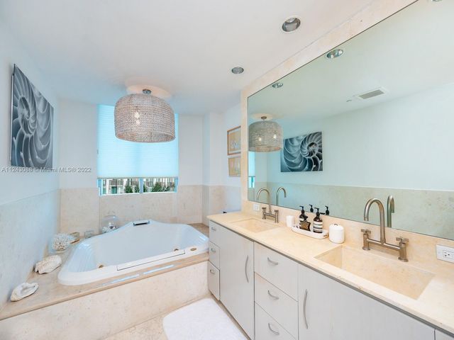 a bathroom with a tub sink and mirror
