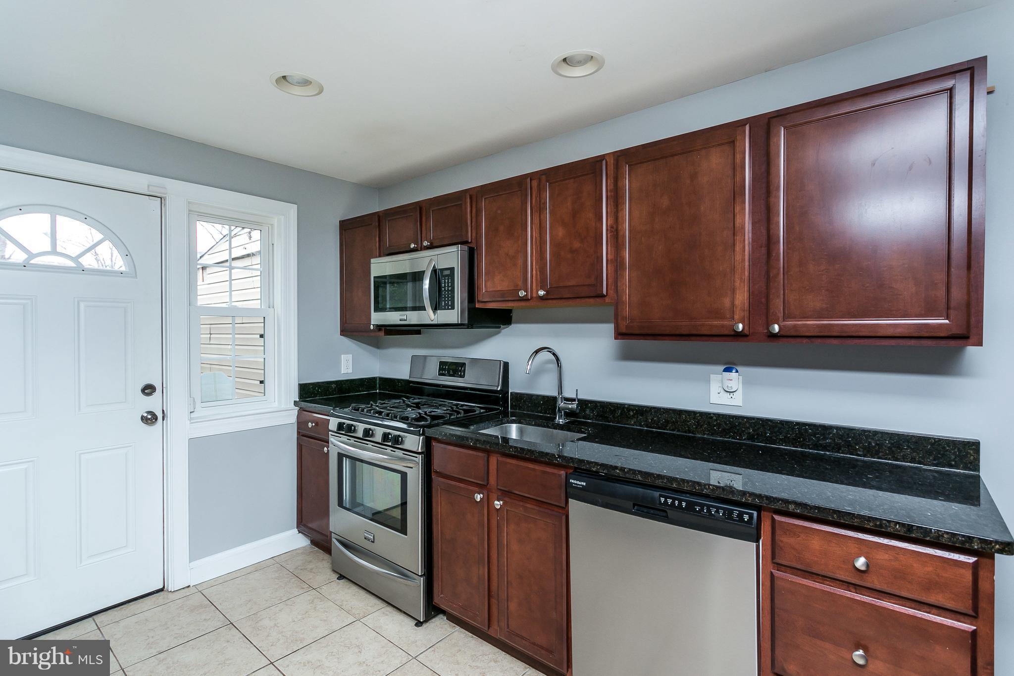 1033 Reverdy Road Baltimore, MD 21212 - Photo 11 of 29 a kitchen with stainless steel appliances granite countertop a stove a sink and a microwave