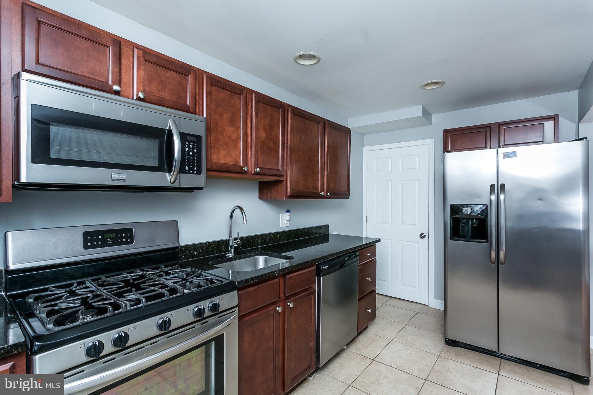 1033 Reverdy Road Baltimore, MD 21212 - Photo 12 of 29 a kitchen with stainless steel appliances granite countertop a stove microwave and refrigerator