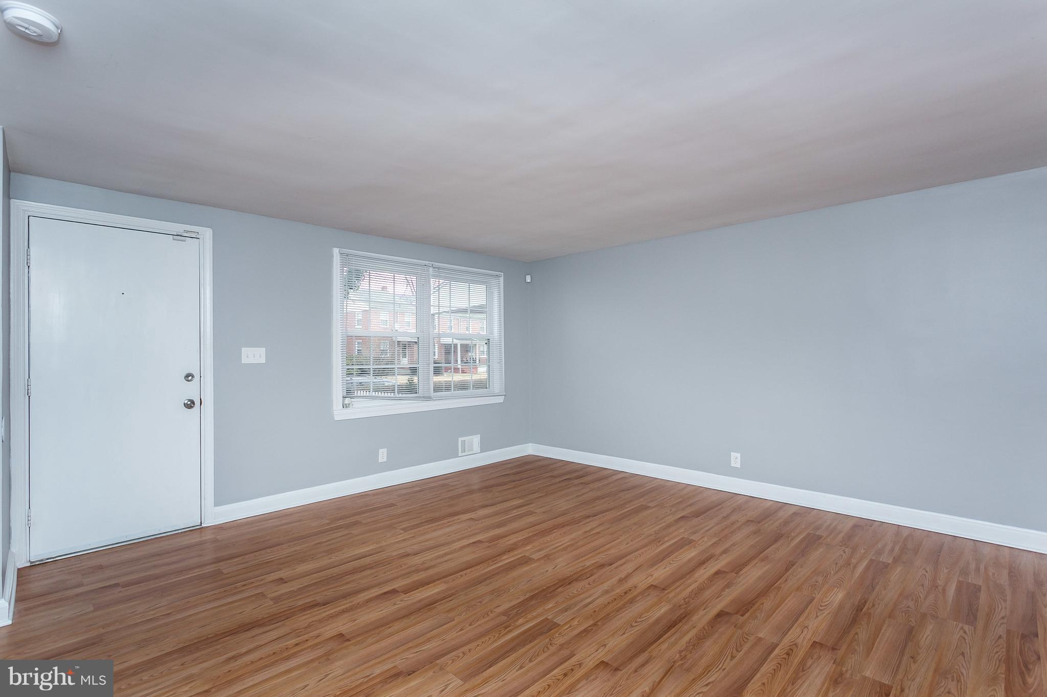 1033 Reverdy Road Baltimore, MD 21212 - Photo 3 of 29 a view of an empty room with wooden floor and a window