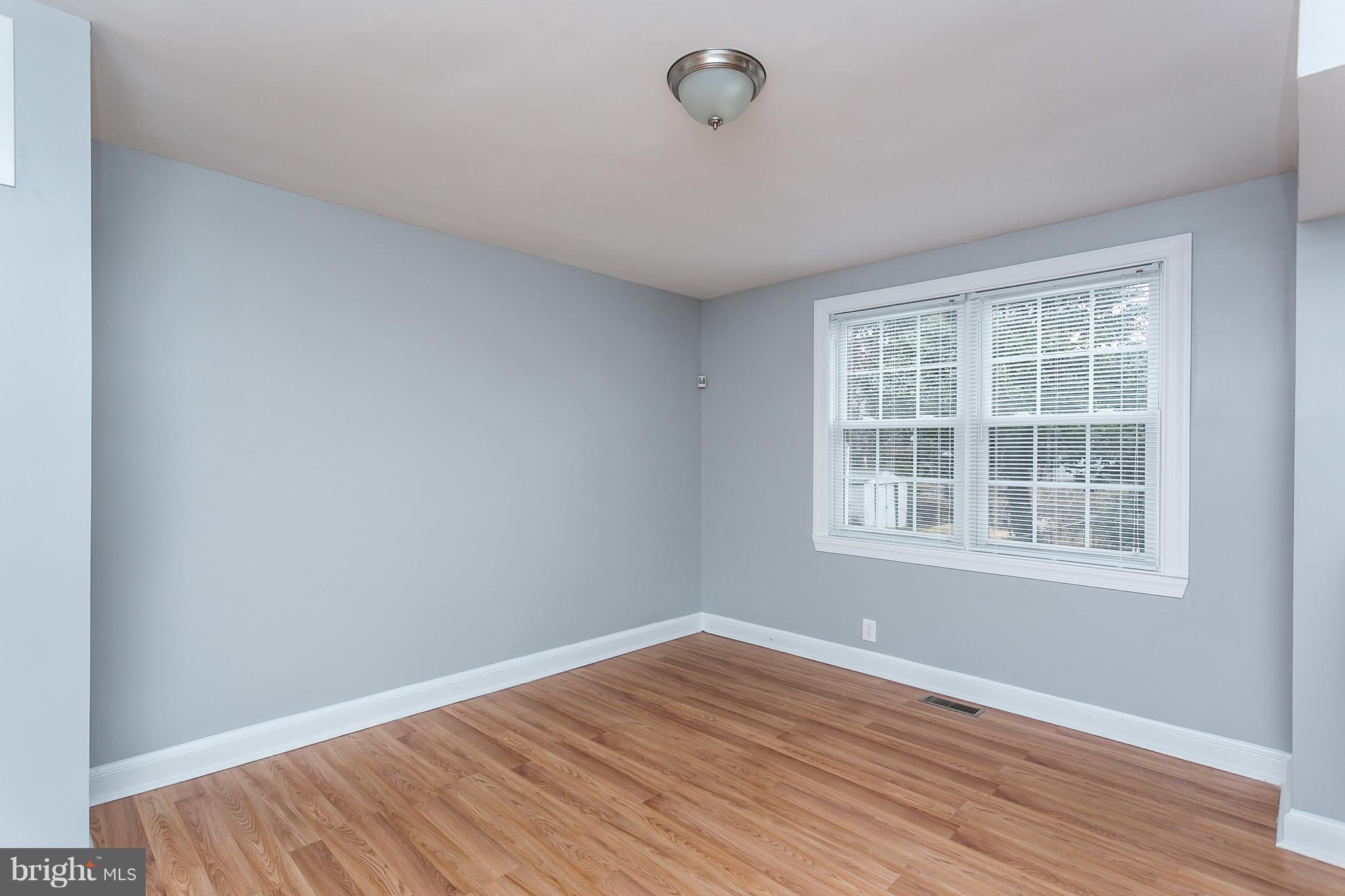1033 Reverdy Road Baltimore, MD 21212 - Photo 7 of 29 an empty room with wooden floor and windows
