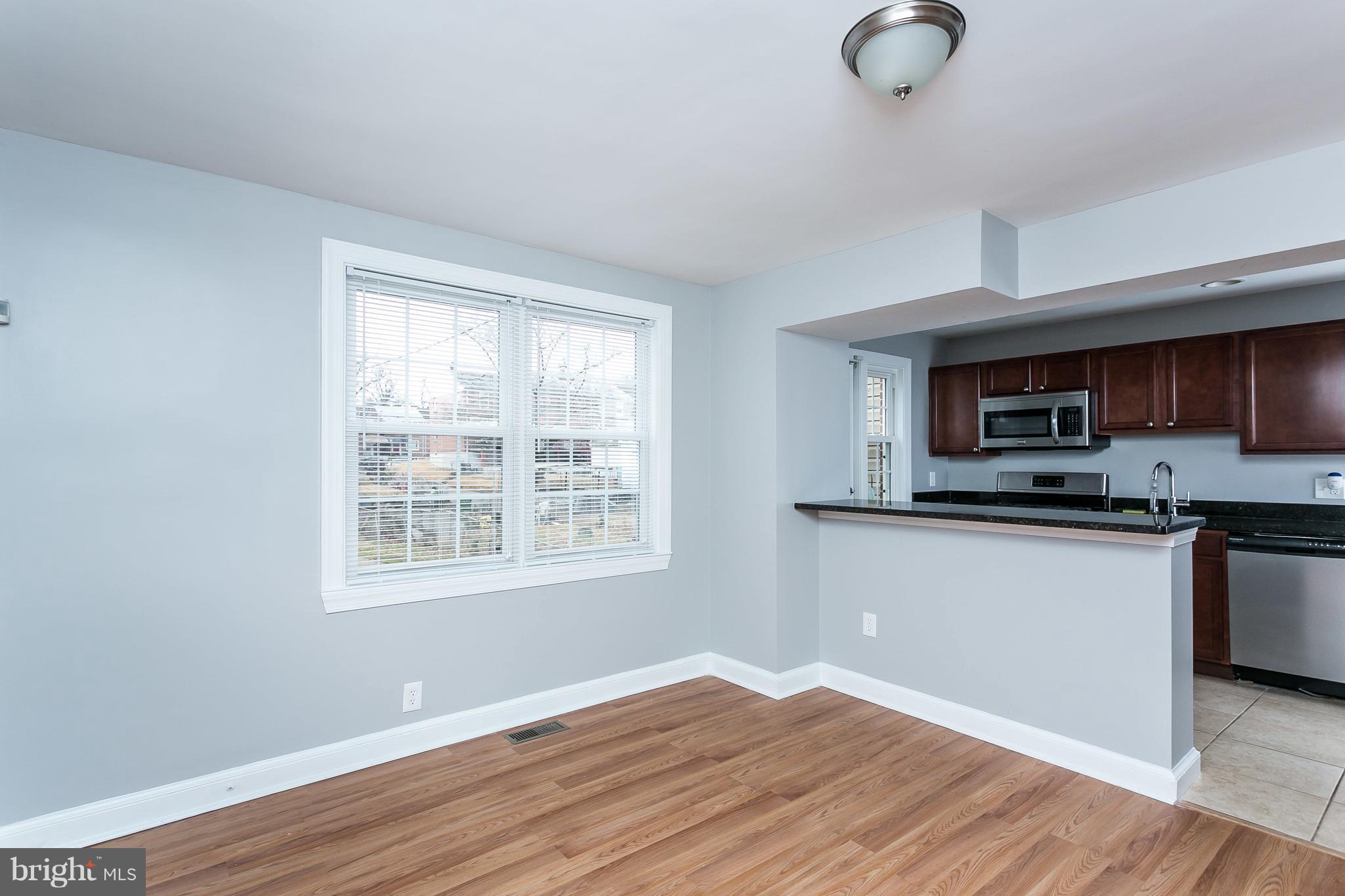1033 Reverdy Road Baltimore, MD 21212 - Photo 8 of 29 a kitchen with granite countertop a stove a sink and a microwave