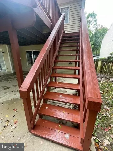 a view of a white house with large tree next to a yard