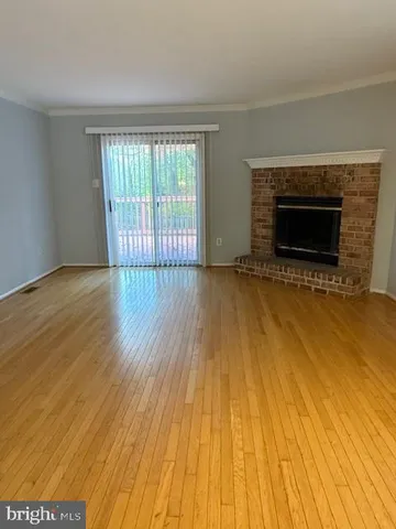 an empty room with wooden floor and fireplace