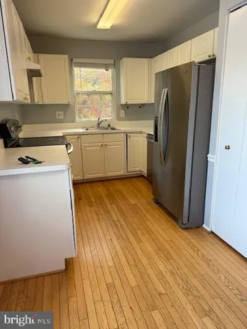 a kitchen with a refrigerator sink and cabinets