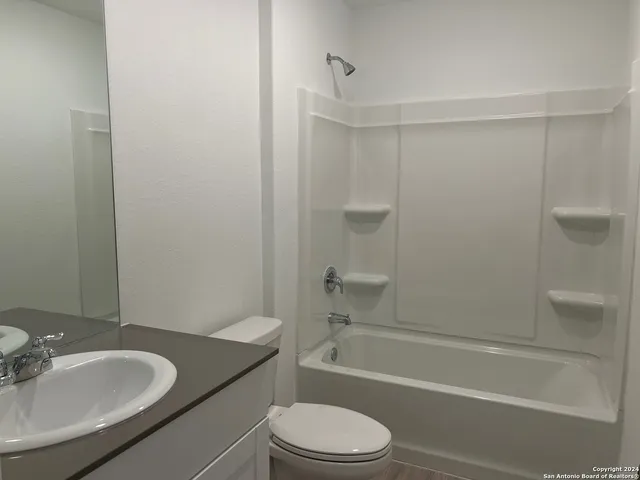 a bathroom with a granite countertop toilet sink and shower