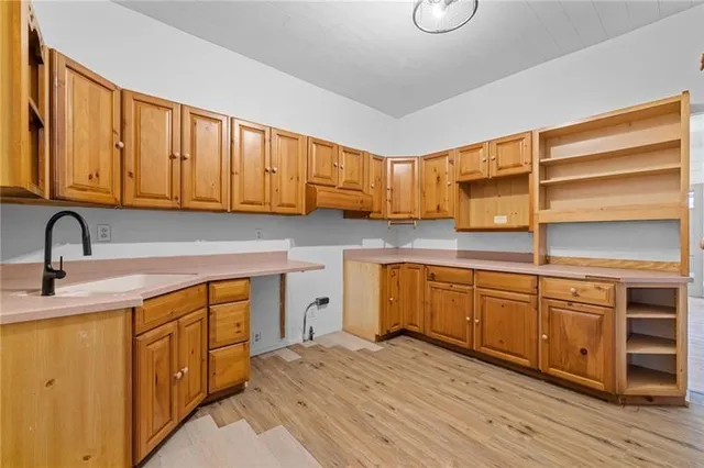 a kitchen with stainless steel appliances granite countertop a sink and cabinets with wooden floor