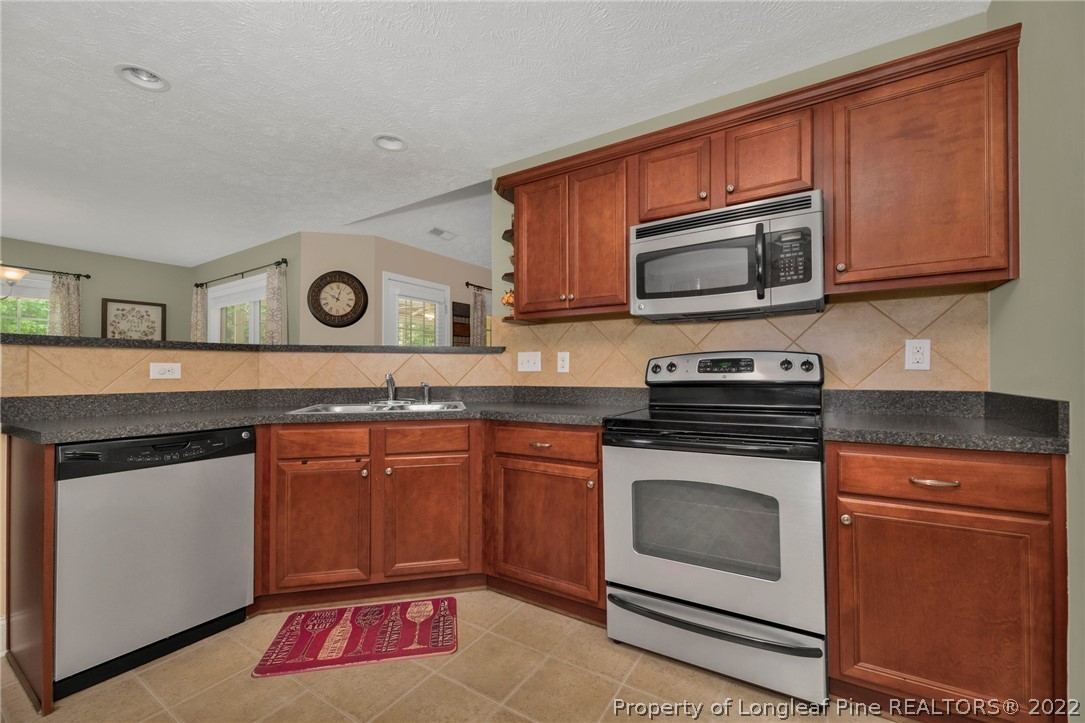 723 Cape Fear Road Raeford, NC 28376 - Photo 15 of 33 a kitchen with stainless steel appliances granite countertop a stove microwave and cabinets