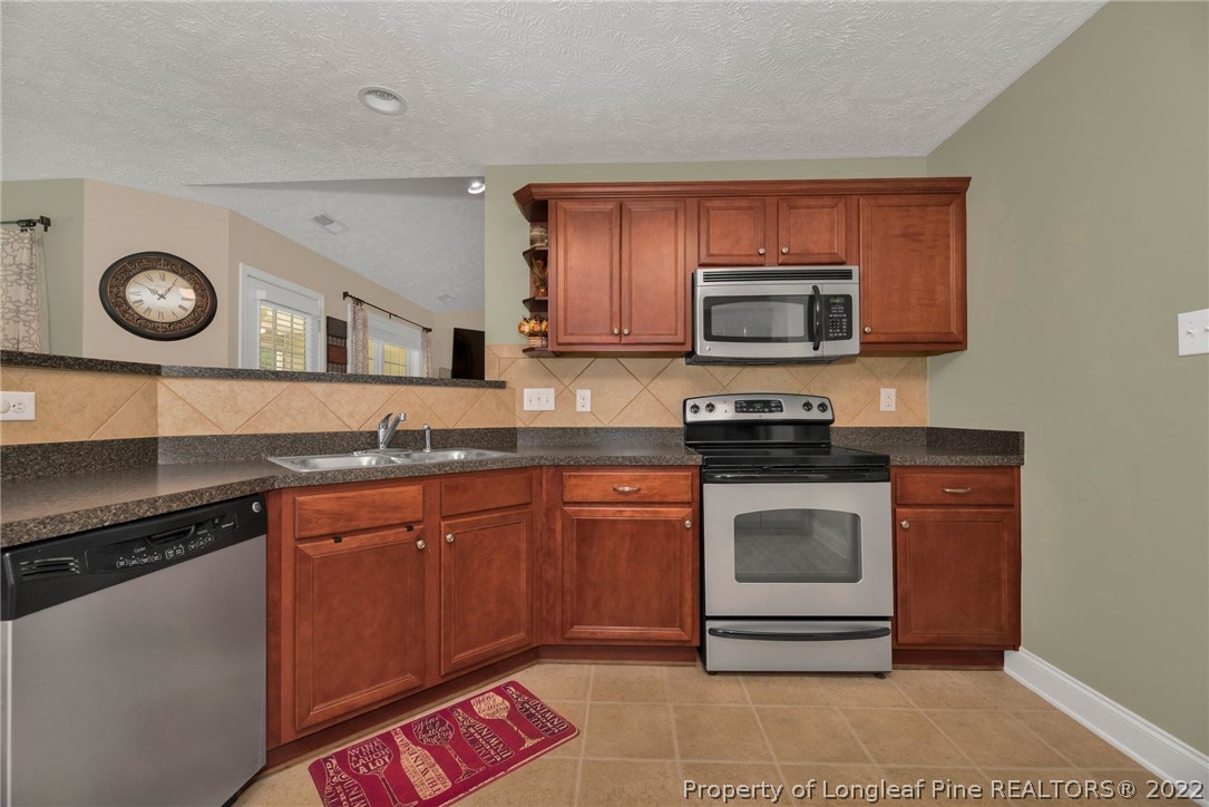 723 Cape Fear Road Raeford, NC 28376 - Photo 17 of 33 a kitchen with granite countertop a stove and a microwave