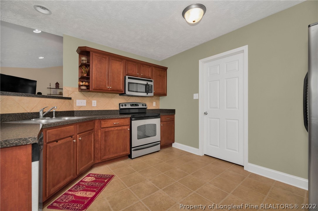 723 Cape Fear Road Raeford, NC 28376 - Photo 18 of 33 a kitchen with stainless steel appliances granite countertop a sink and cabinets