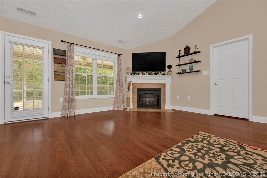 723 Cape Fear Road Raeford, NC 28376 - Photo 10 of 33 a view of empty room with wooden floor and fireplace