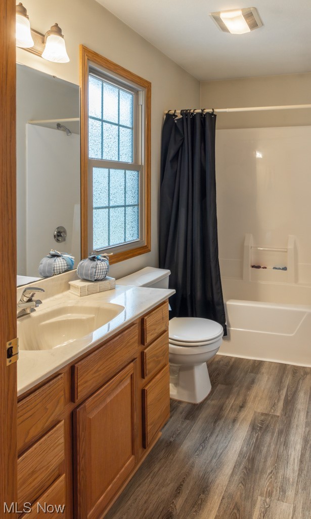 8383 Ickes Road Wooster, OH 44691 - Photo 23 of 32 Full bathroom with vanity with extensive cabinet space, shower / bath combo with shower curtain, wood-type flooring, and toilet