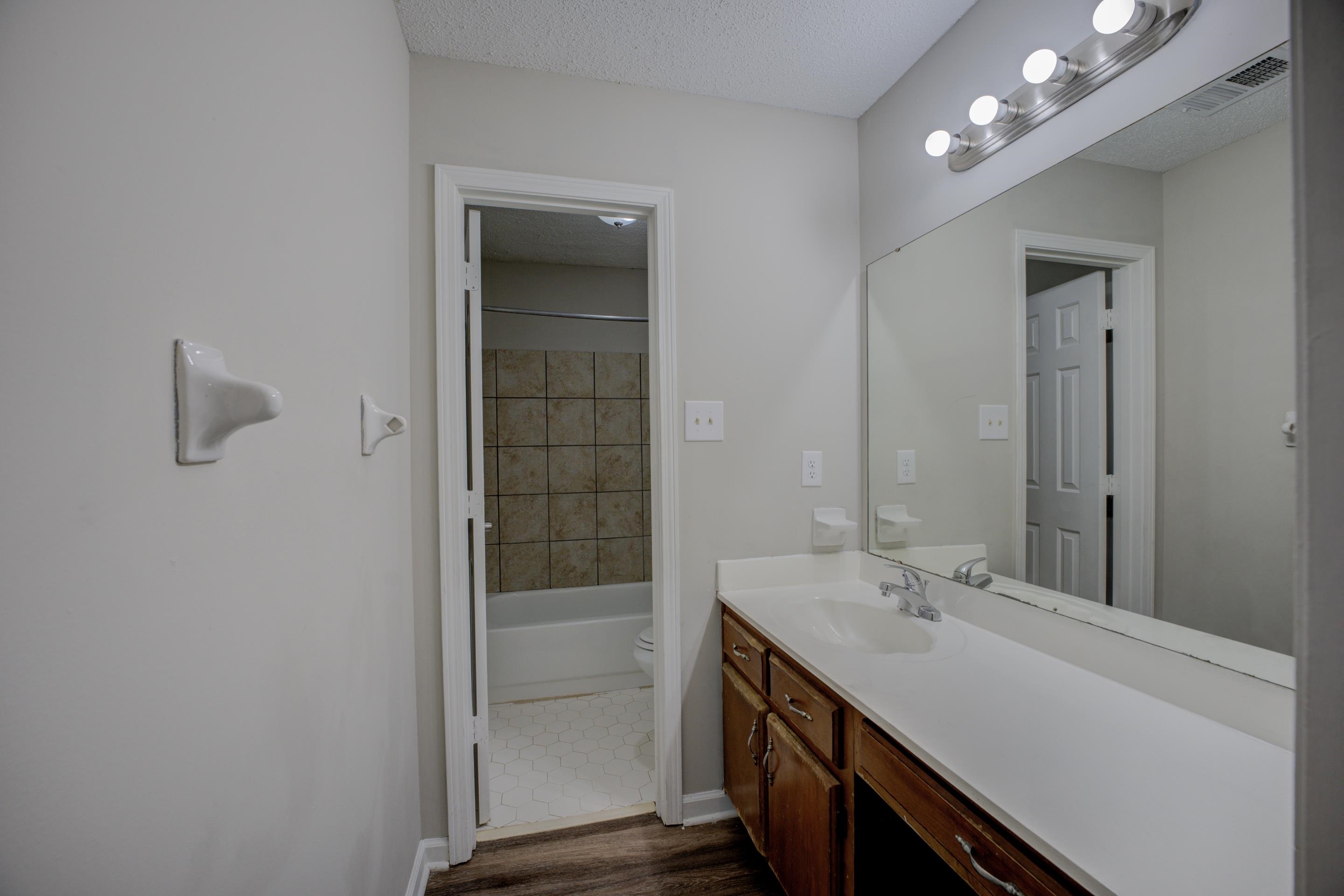 3501 Chowning Road Memphis, TN 38135 - Photo 4 of 25 Full bathroom featuring tiled shower / bath, wood-type flooring, vanity, toilet, and a textured ceiling