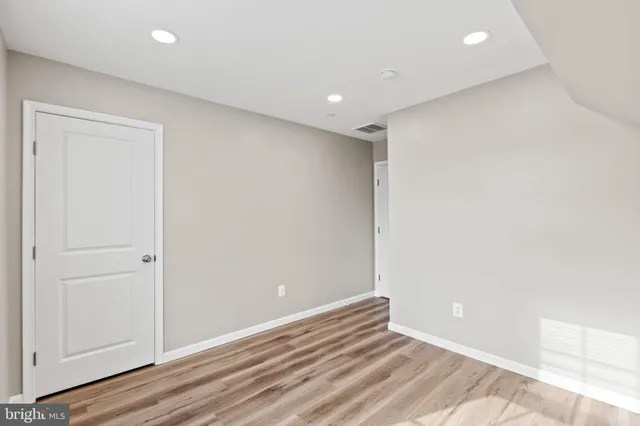 an empty room with wooden floor and closet