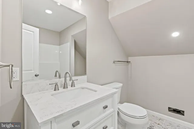 a bathroom with a sink toilet vanity and shower