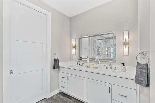 a bathroom with a double vanity sink and mirror