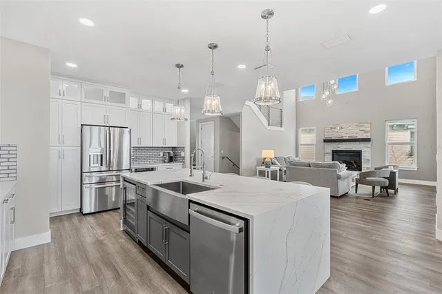 a kitchen with kitchen island a stove a center island a sink cabinets and wooden floor