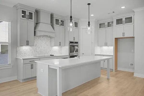 a kitchen with a sink dishwasher a stove and a refrigerator with wooden floor